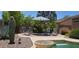 Inviting backyard pool area with desert landscaping, chairs, and striped umbrella at 2894 N Paisley Ave, Casa Grande, AZ 85122