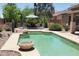 Relaxing backyard pool with lounge chairs, desert landscaping, and striped umbrella at 2894 N Paisley Ave, Casa Grande, AZ 85122