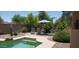 Inviting backyard pool area with lounge chairs, desert landscaping, and a striped umbrella at 2894 N Paisley Ave, Casa Grande, AZ 85122