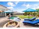 Stunning backyard with a private pool, a fire pit, and manicured lawn offering the ultimate outdoor living experience at 35952 W Catalonia Dr, Maricopa, AZ 85138