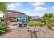 This backyard oasis boasts a sparkling pool, lush greenery, a fire pit, and lounge chairs for relaxing at 35952 W Catalonia Dr, Maricopa, AZ 85138