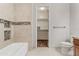 Bathroom featuring a tiled tub and a doorway to a walk-in closet with shelving at 35952 W Catalonia Dr, Maricopa, AZ 85138