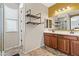 This bathroom boasts double sinks with wood cabinets and custom shelving on the wall at 35952 W Catalonia Dr, Maricopa, AZ 85138