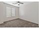 A bedroom featuring neutral paint, carpet, a window that lets in natural light and a ceiling fan at 35952 W Catalonia Dr, Maricopa, AZ 85138
