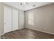Neutral bedroom with hardwood flooring, a window with blinds, and a large closet at 35952 W Catalonia Dr, Maricopa, AZ 85138