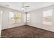 Bright bedroom featuring neutral carpet, multiple windows for natural light, and a ceiling fan at 35952 W Catalonia Dr, Maricopa, AZ 85138