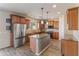 A spacious kitchen with wood cabinets, granite countertops, a large island, and stainless steel appliances at 35952 W Catalonia Dr, Maricopa, AZ 85138