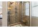 Shower with glass door, stone accent wall, built in niche, and bench at 35952 W Catalonia Dr, Maricopa, AZ 85138
