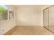 This bedroom features neutral walls, tile flooring, and a bright window and sliding closet door at 440 S Parkcrest -- # 145, Mesa, AZ 85206