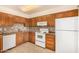 Traditional kitchen features wood cabinets, granite countertops, white appliances, and tile flooring at 440 S Parkcrest -- # 145, Mesa, AZ 85206