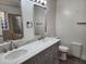 Well-lit bathroom featuring a double vanity, decorative mirrors, and a shower with glass doors at 4534 E Villa Maria Dr, Phoenix, AZ 85032