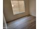 Comfortable bedroom with wood-look floors and window, filled with natural light at 4534 E Villa Maria Dr, Phoenix, AZ 85032