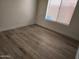 Cozy bedroom features wood-look floors and a window with bright natural light at 4534 E Villa Maria Dr, Phoenix, AZ 85032