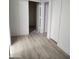 Hallway showcasing updated wood-look flooring and doorways leading to other rooms at 4534 E Villa Maria Dr, Phoenix, AZ 85032