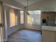 Sunlit kitchen nook with large windows, stainless steel refrigerator, and stylish hanging light fixture at 4534 E Villa Maria Dr, Phoenix, AZ 85032
