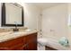 Bathroom featuring granite counters, framed mirror and tile surround tub at 4802 W Hayward Ave, Glendale, AZ 85301