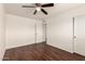 Bedroom with dark wood floor, ceiling fan, and a double door closet at 4802 W Hayward Ave, Glendale, AZ 85301
