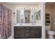 Bathroom with double sinks, vanity, mirrors, and shower curtain, providing a functional space at 4912 W Marco Polo Rd, Glendale, AZ 85308