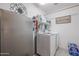 Functional laundry room featuring a washer, dryer, and shelving for storage at 4912 W Marco Polo Rd, Glendale, AZ 85308