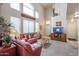 Bright living room featuring a high ceiling, large windows and a comfortable red leather sofa set at 4912 W Marco Polo Rd, Glendale, AZ 85308