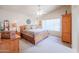 Main bedroom with vaulted ceiling, ceiling fan, large windows, and wooden furnishings at 4912 W Marco Polo Rd, Glendale, AZ 85308