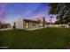 View of home exterior, lush artificial turf, white wall and outdoor play area in this backyard at 5309 E Hearn Rd, Scottsdale, AZ 85254