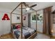 A bright bedroom with a canopy bed, hardwood floors, a ceiling fan and a view to the outdoors at 5309 E Hearn Rd, Scottsdale, AZ 85254