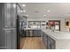 Kitchen featuring gray cabinetry, stainless steel appliances, and a large island with a waterfall countertop at 5309 E Hearn Rd, Scottsdale, AZ 85254