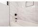 Close up of the shower and tub in the bathroom featuring black hardware and a white marble tile surround at 5499 E Red Bird Ln, San Tan Valley, AZ 85140