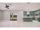 Open-concept living room with modern flooring, a sliding glass door, and seamless transition to the stylish kitchen at 5499 E Red Bird Ln, San Tan Valley, AZ 85140