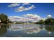 Expansive lake view with serene waters, reflecting a blue sky with puffy clouds, and houses in the background at 7120 N Via De La Sendero --, Scottsdale, AZ 85258