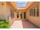 Charming courtyard entry with stucco walls, tile flooring, double front doors, and ample sunlight at 8171 E Del Caverna Dr, Scottsdale, AZ 85258