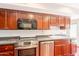 Stylish kitchen with stainless steel appliances, dark wood cabinetry, and stone countertops at 8171 E Del Caverna Dr, Scottsdale, AZ 85258