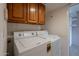 Functional laundry room with washer, dryer, and ample cabinet space for storage at 8171 E Del Caverna Dr, Scottsdale, AZ 85258