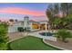 Backyard with pool, putting green and landscaping with desert vegetation at dusk at 8196 E Sunnyside Dr, Scottsdale, AZ 85260