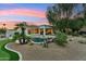 Backyard with pool, artificial turf putting green and desert landscaping at dusk at 8196 E Sunnyside Dr, Scottsdale, AZ 85260