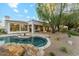 Beautiful backyard pool with rock features and lush landscaping, perfect for outdoor relaxation and entertainment at 8196 E Sunnyside Dr, Scottsdale, AZ 85260