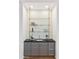 Elegant bar area featuring stone countertops, custom cabinetry, and open shelving for displaying glassware at 8196 E Sunnyside Dr, Scottsdale, AZ 85260