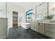 Bright bathroom featuring a soaking tub, marble countertop, black tile flooring, and a walk-in closet at 8196 E Sunnyside Dr, Scottsdale, AZ 85260