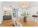 Bright dining room showcases a modern chandelier, natural wood table, and a built-in bar for entertaining at 8196 E Sunnyside Dr, Scottsdale, AZ 85260