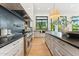 Modern kitchen featuring stainless steel appliances, black countertops, and a light wood floor at 8196 E Sunnyside Dr, Scottsdale, AZ 85260