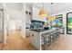 Open kitchen with a large island, modern pendant lights, and light wood floors at 8196 E Sunnyside Dr, Scottsdale, AZ 85260