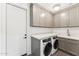 Laundry room featuring modern appliances, gray cabinets, and ample countertop space at 8196 E Sunnyside Dr, Scottsdale, AZ 85260