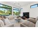Open-concept living room with floor-to-ceiling windows offering stunning views of the lush green landscape at 8196 E Sunnyside Dr, Scottsdale, AZ 85260