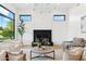 Bright living room featuring a cozy fireplace, modern lighting, and an expansive window with neighborhood views at 8196 E Sunnyside Dr, Scottsdale, AZ 85260