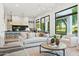 Bright, open living room connected to a modern kitchen, featuring light wood floors and large windows at 8196 E Sunnyside Dr, Scottsdale, AZ 85260