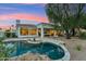 View of kidney shaped pool and desert landscaping in backyard at dusk at 8196 E Sunnyside Dr, Scottsdale, AZ 85260