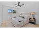Well-lit bedroom features a ceiling fan, large window, and neutral decor at 8732 E Arlington Rd, Scottsdale, AZ 85250