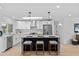 Modern kitchen boasts white cabinets, stainless steel appliances, a skylight, and a large island with stool seating at 8732 E Arlington Rd, Scottsdale, AZ 85250