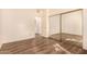 Bedroom featuring wood floors, mirrored closet doors, and access to hallway and bathroom at 930 N Mesa Dr # 1023, Mesa, AZ 85201